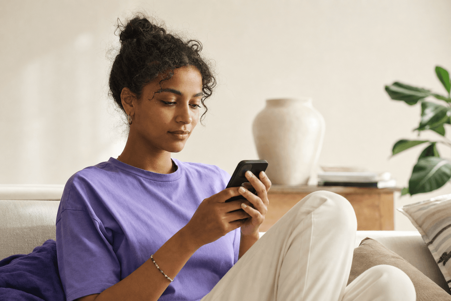 Ung person som ser på influencer-innhold på telefon, med tydelig annonsemerking synlig på skjermen