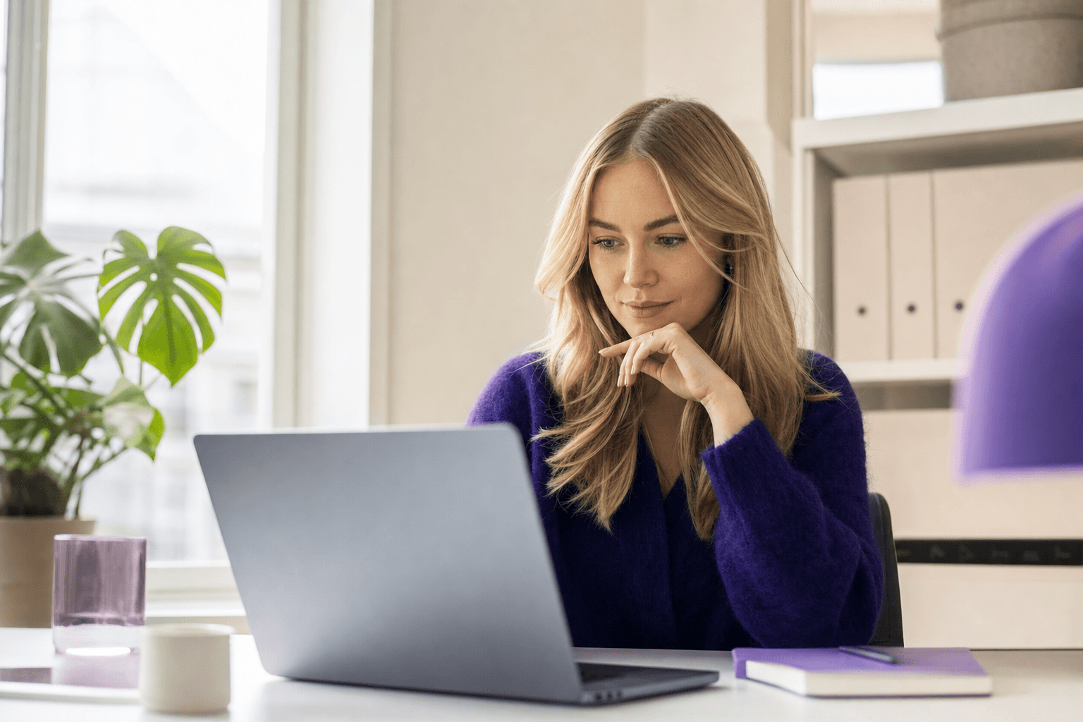 Markedsansvarlig sammenligner mikro- og makroinfluencer-profiler på laptop i et lyst, moderne kontor