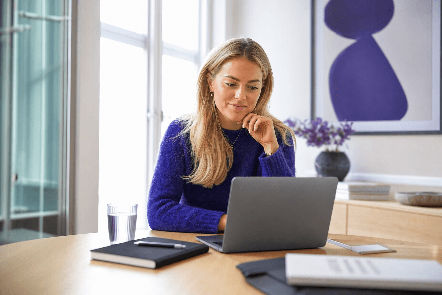 Markedsansvarlig ser på influencer-kampanje-analyse på laptop i et lyst, moderne kontor